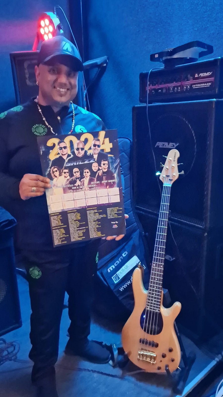 Skilzz bassist met Skilzz jaarkalender naast zijn bas